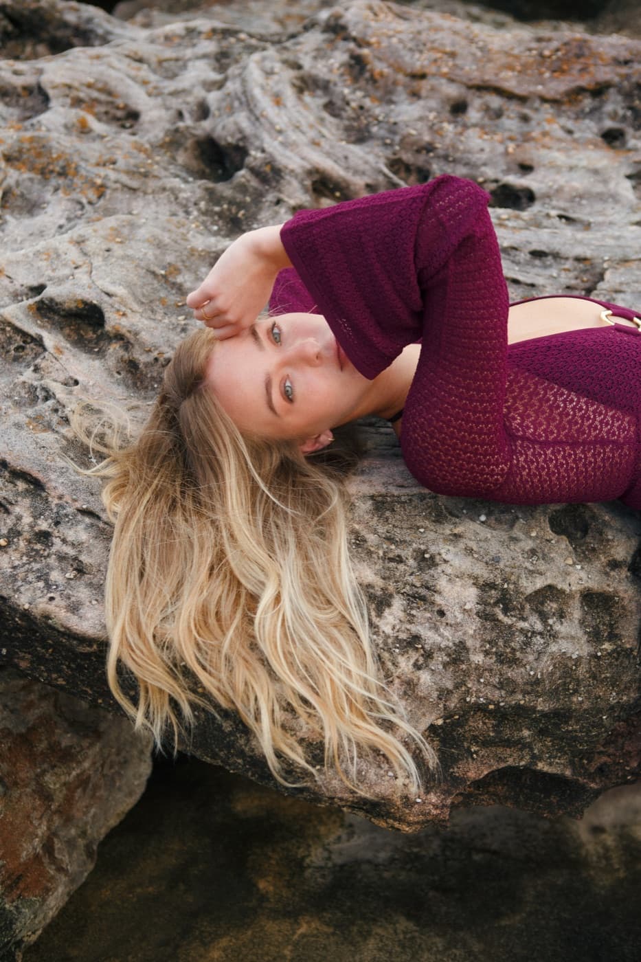 Long blonde hair styled on a rocky coastline